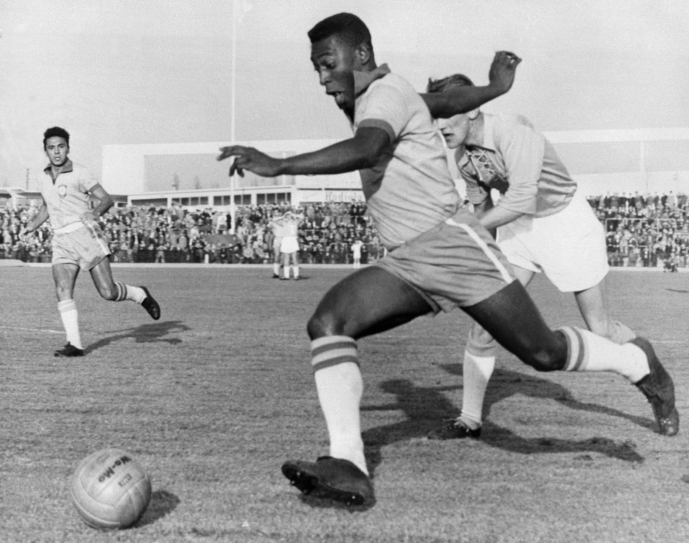 Pelé dribbling past a defender during Malmö-Brazil 1-7 (Pelé scored 2 goals) at Malmö city stadium .