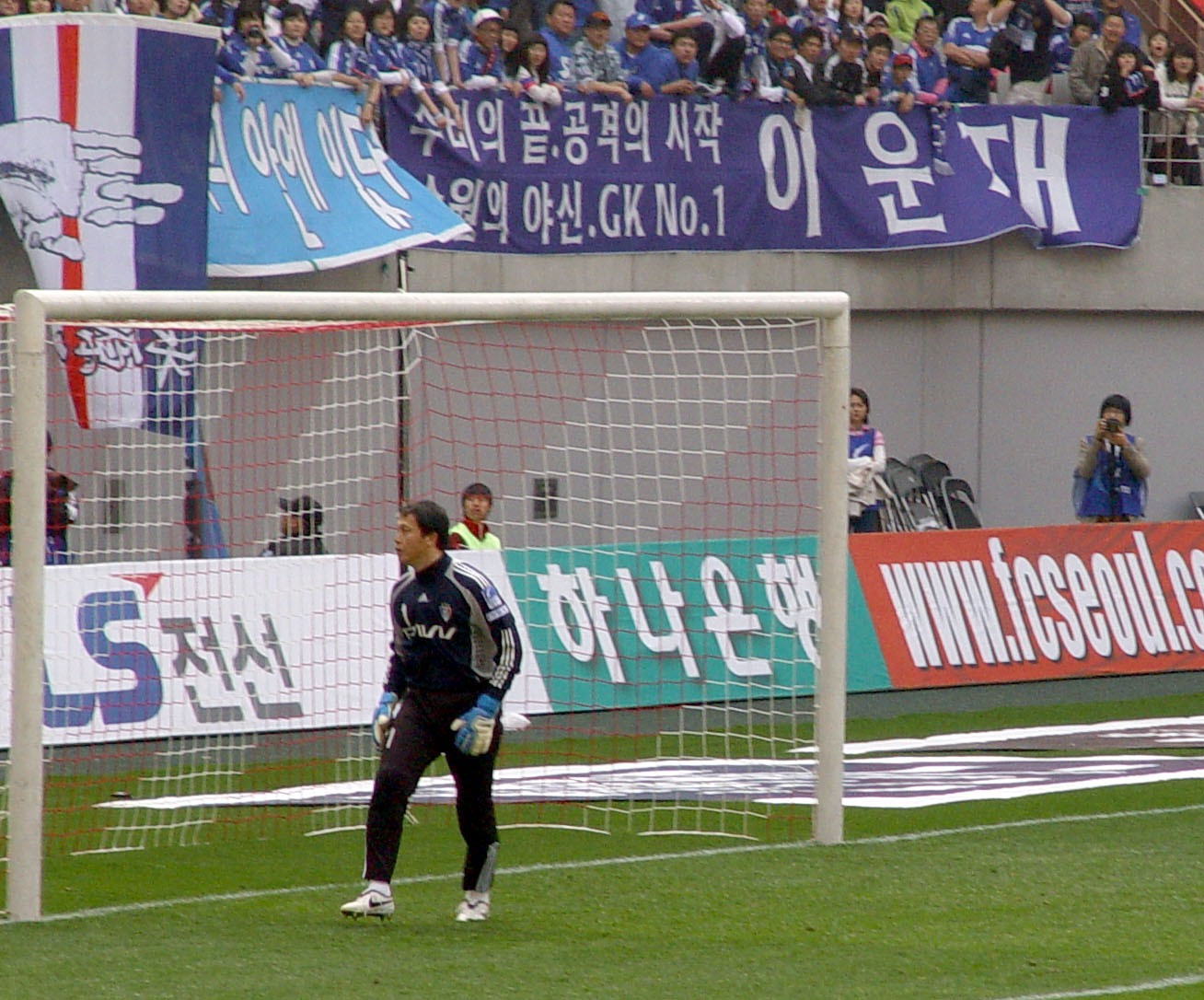 Lee Woon-jae in goalkeeper kit standing in front of the goal.