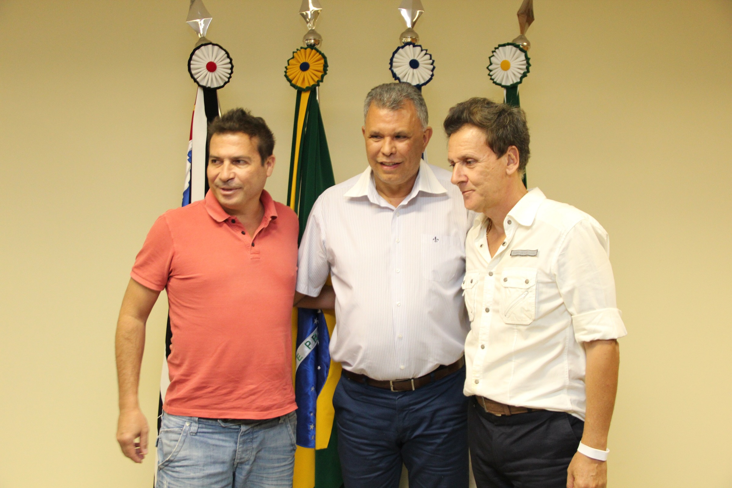 Luizão, left in a red polo shirt, standing with two men at a municipal event in Paulínia in 2018.