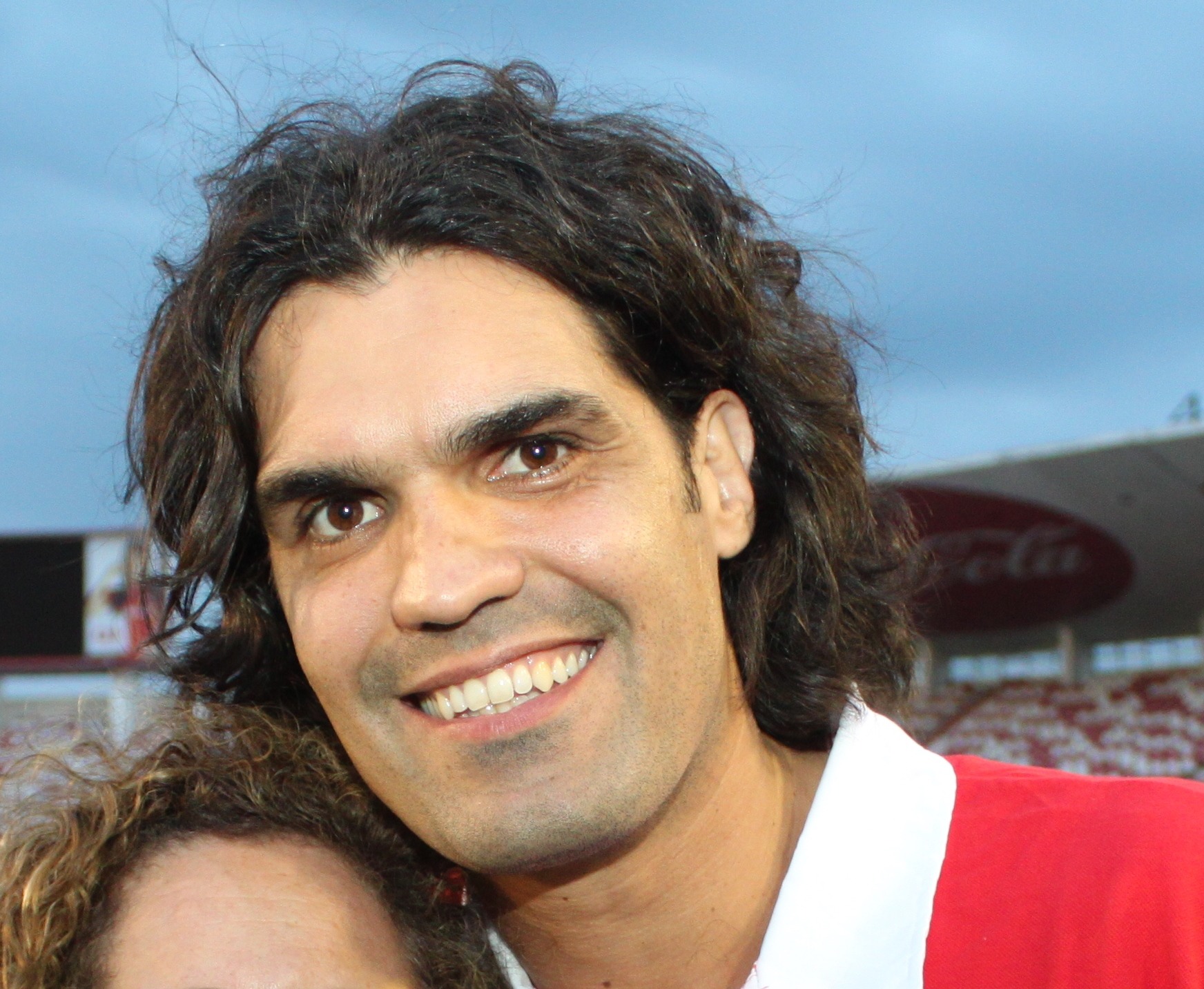 Fernandão smiling for a photograph at a football stadium in 2011.