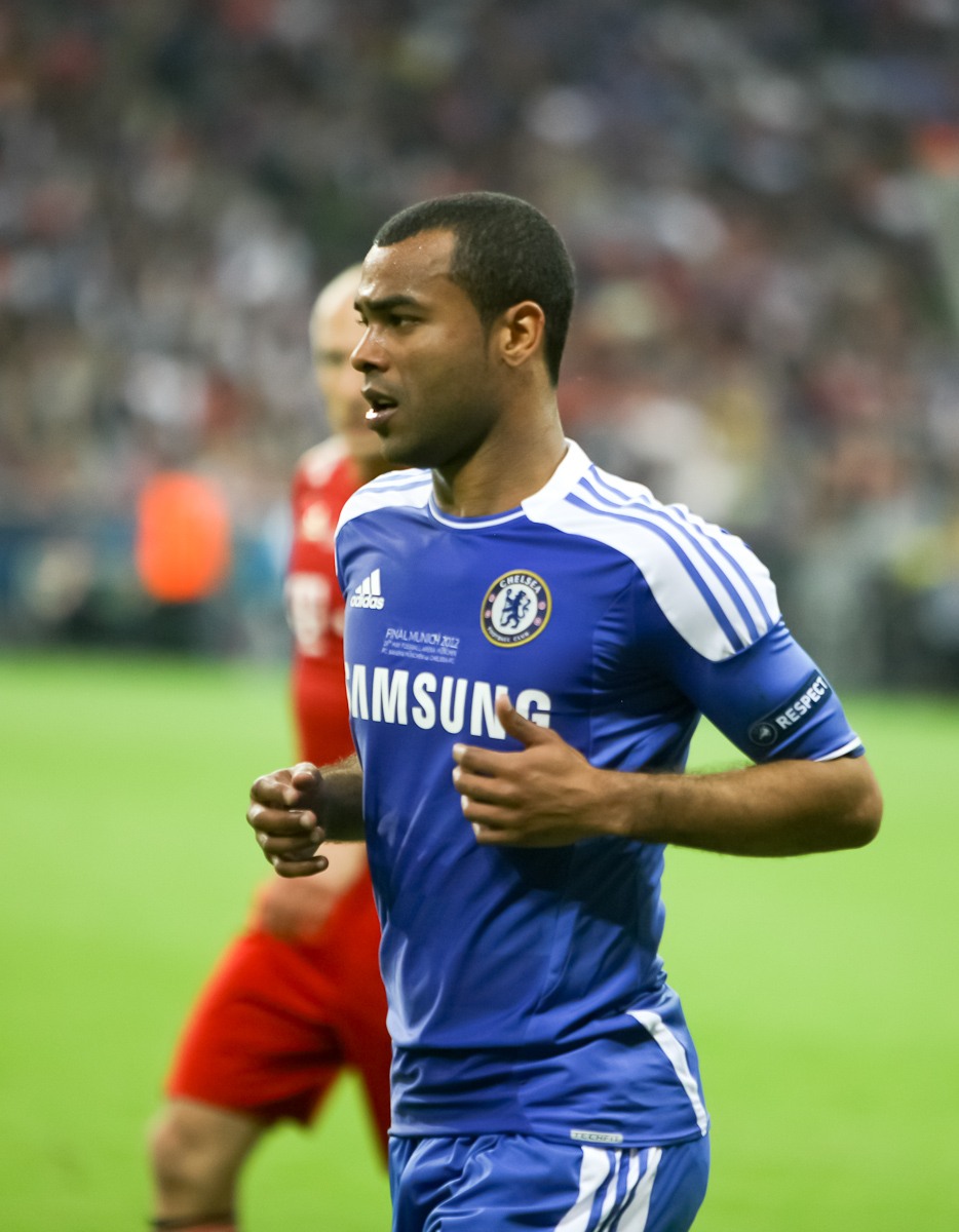 Ashley Cole jogging in Chelsea's blue kit on the pitch in 2012.