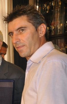 Theodoros Zagorakis in a light-coloured polo shirt at an indoor event.
