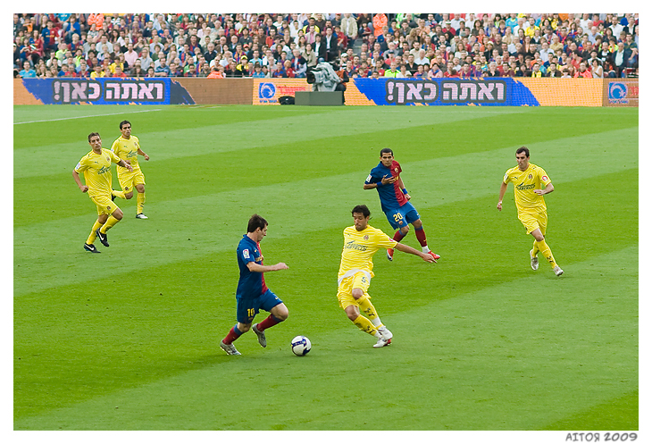 Messi controlling the ball in front of a Villarreal defender.